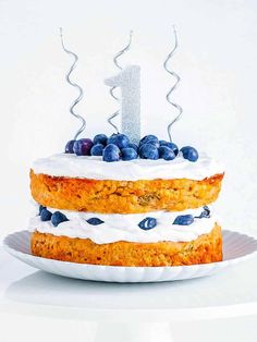 a birthday cake with blueberries and white frosting