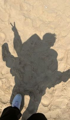 the shadow of a person standing in the sand