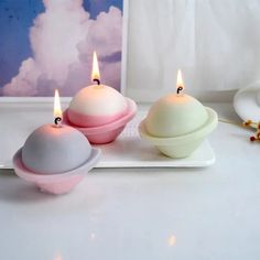 three candles sitting on top of a white tray