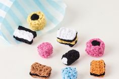 small crocheted pastries sitting on top of a white table next to a paper bag