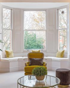 a living room filled with furniture and large windows