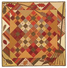 an orange and yellow quilt with leaves on it's sides, in the shape of a square