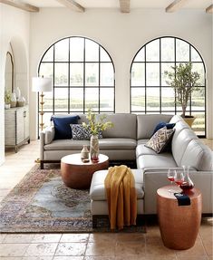 a living room filled with lots of furniture and large windowed windows in the wall