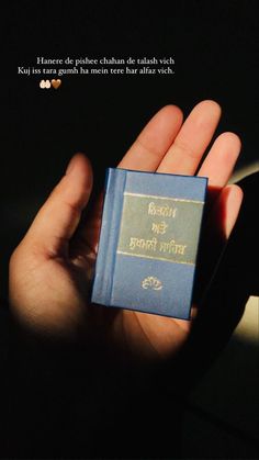 a person holding a small blue book in their hand