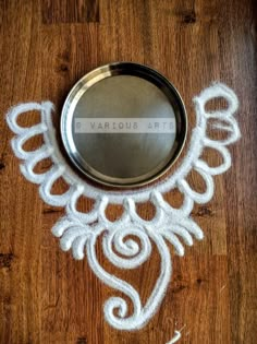 a mirror sitting on top of a wooden floor covered in white paint and angel wings