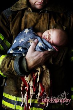 a firefighter holding a baby in his arms