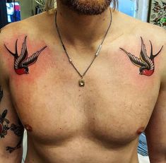 a man's chest with two birds on it and a red apple in the middle