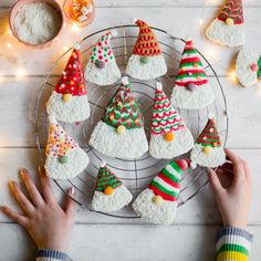 someone is decorating christmas cookies on a wire rack