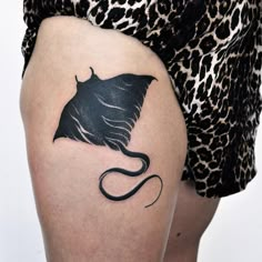 a woman's thigh with a tattoo of a stingfish on the lower leg