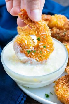 a person dipping some food into a bowl