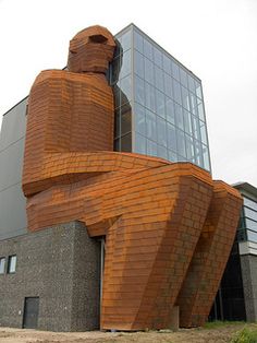 a large wooden sculpture sitting in front of a building