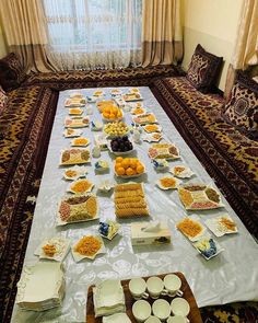 a long table covered with plates and bowls filled with different types of food on it