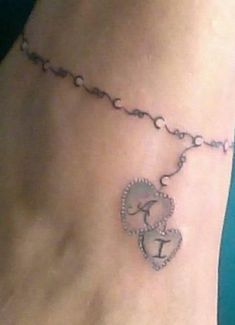 a woman's foot with a tattoo on the ankle and a chain attached to it