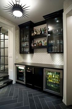 a home bar with black cabinets and white tile flooring is featured in this photo