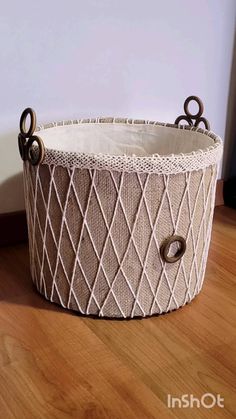 a basket that is on the floor with some scissors in it's handle and handles