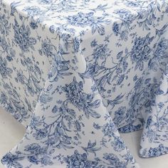 a blue and white table cloth with floral designs on it, set against a white background