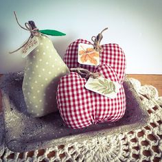 two apples and a pear sitting on a tray with a doily lace doily