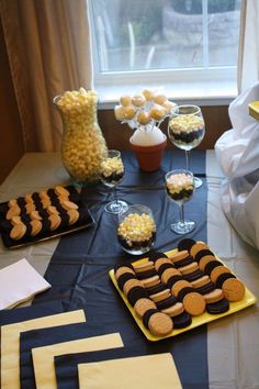 a table topped with cookies and desserts next to a window