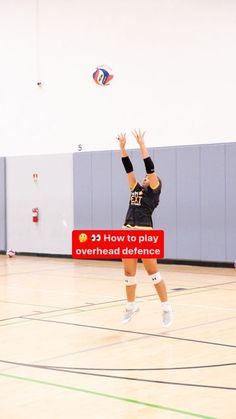 a volleyball player jumping up to hit the ball with her racket in an indoor gym