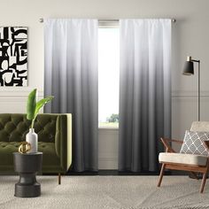 a living room filled with furniture and a green couch next to a window covered in black and white curtains