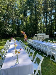 a long table set up with flowers and balloons