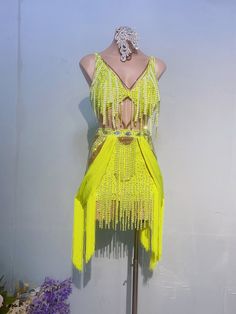 a mannequin wearing a yellow dress with fringes on it's sides