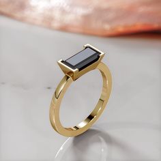 a gold ring with a black stone on it