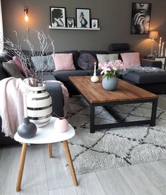 a living room filled with furniture and decor on top of a wooden table in front of a gray couch