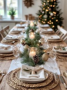 a table set for christmas dinner with pine cones and candles