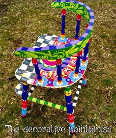 a colorful painted chair sitting in the grass