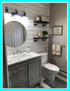 a white toilet sitting next to a sink in a bathroom under a mirror and lights