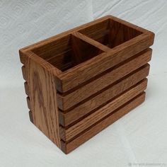 a wooden box that is sitting on a white tablecloth with the lid open and four compartments in it