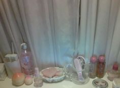 there are many items on the counter in front of the window, including soaps and toothbrushes