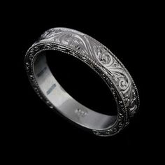 a wedding ring with intricate engraving on the side and an engraved pattern in the middle