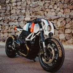 a motorcycle parked in front of a stone wall