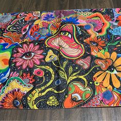 an artistically designed placemat on a wood floor with flowers and birds painted on it