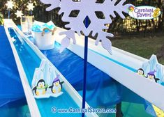 a snowflake decoration on top of an ice rink with penguins in the background