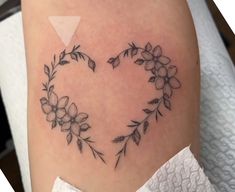 a heart shaped tattoo with flowers on it