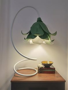 a lamp that is sitting on top of a table next to a bowl and book