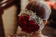 a woman is holding flowers in her hair