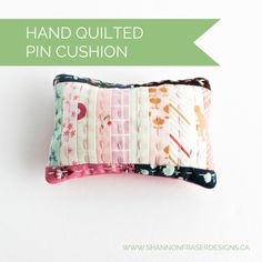 a pillow made out of fabric with the words hand quilted pin cushion