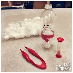 a plastic snowman is next to some scissors and a bottle with something in it