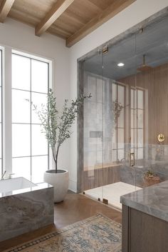 a bathroom with a tub, sink and large window in it's center area