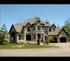 a large house with two car garages on the front and one story above it