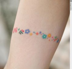 a woman's leg with flowers and stars on the lower part of her arm