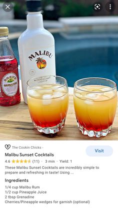 two glasses filled with drinks sitting on top of a wooden table