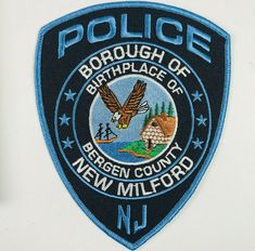 a police badge is shown on the side of a white truck with blue writing and an eagle