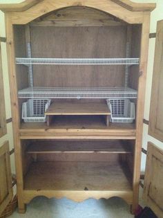 a wooden cabinet with shelves and baskets in it