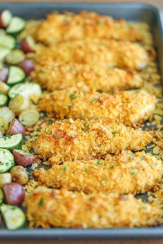 chicken and vegetables on a baking sheet with parmesan bread crumbs in the middle