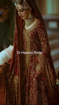 a woman in a red and gold bridal gown is standing next to a man